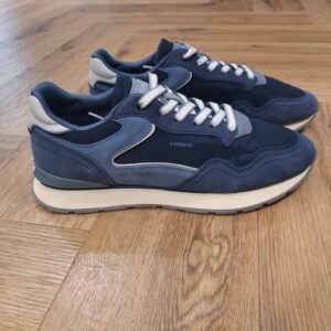 City Navy Blue La sneaker City Navy Blue est une silhouette urbaine conçue à partir d’une combinaison soignée de matériaux premium, de finitions de qualité et d’une palette de couleurs attractive. Pour commencer, elle est légère, stable et elle offre un excellent maintien. De plus, elle associe parfaitement praticité et élégance. Puis, sa semelle intérieure en Memory Foam s’adapte à la forme du pied et à la démarche pour un confort anatomique à chaque pas. Elle possède, une languette souple et un talon rembourré, tous deux siglés du logo de la marque. La marque Fondée en Espagne en 2017, HOFF est née de la conviction que chaque pas est une opportunité de créer, découvrir et affirmer sa personnalité. HOFF est une marque contemporaine de sneakers qui marie un design intemporel et élégant avec une polyvalence audacieuse. Reconnue pour sa créativité raffinée, son attention aux détails et sa maîtrise unique des couleurs, HOFF crée des sneakers qui s’adaptent aux transitions de la vie, transformant chaque instant du quotidien en une expression de style et de sens. Inspirée par le mouvement et la curiosité, HOFF célèbre l’individualité et l’expression de soi à travers le design. Son esthétique distinctive équilibre sophistication et modernité, brouillant les frontières entre le décontracté et le raffiné, tout en restant fidèle à ses valeurs de connexion, d’authenticité, de passion et de créativité.