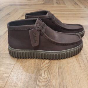 Torhill Hi Dark Brown Le Torhill Hi, au style inspiré des archives, reprend des éléments de design de deux classiques Clarks : l’emblématique Wallabee et le Big Gripper des années 90. Avec sa silhouette élégante à fermeture à lacets, héritée du premier, et sa semelle en TPR ultra-épaisse caractéristique du second, ce modèle offre une alternative chic et décontractée aux baskets lorsque les températures baissent. Fort d’une esthétique vintage marquée et doté de caractéristiques de confort modernes, il intègre une assise plantaire Contour Cushion amovible qui assure un soutien moelleux à chaque pas. Nos fondateurs Notre histoire a commencé en 1825 à Street, dans le Somerset, lorsque Cyrus Clark a ouvert une tannerie de cuir, son frère James travaillant à ses côtés. Parmi les tapis en peau de mouton, James a eu un éclair d'inspiration : utiliser les chutes pour créer des pantoufles - minimiser les déchets, maximiser l'ingéniosité et définir les 200 prochaines années de la fabrication de chaussures. Chaque chaussure Clarks, depuis notre toute première paire, utilise cette combinaison distinctive d'innovation et de savoir-faire, soutenant tout ce que nous faisons. Depuis 200 ans, nous avons défini la norme - et ce n'est que le début. En 2025, nous rendons hommage au passé et au présent et célébrons fièrement cet héritage de deux siècles d'innovation et d'impact à travers un tout nouveau film, un livre, une exposition de musée et des collaborations de style.