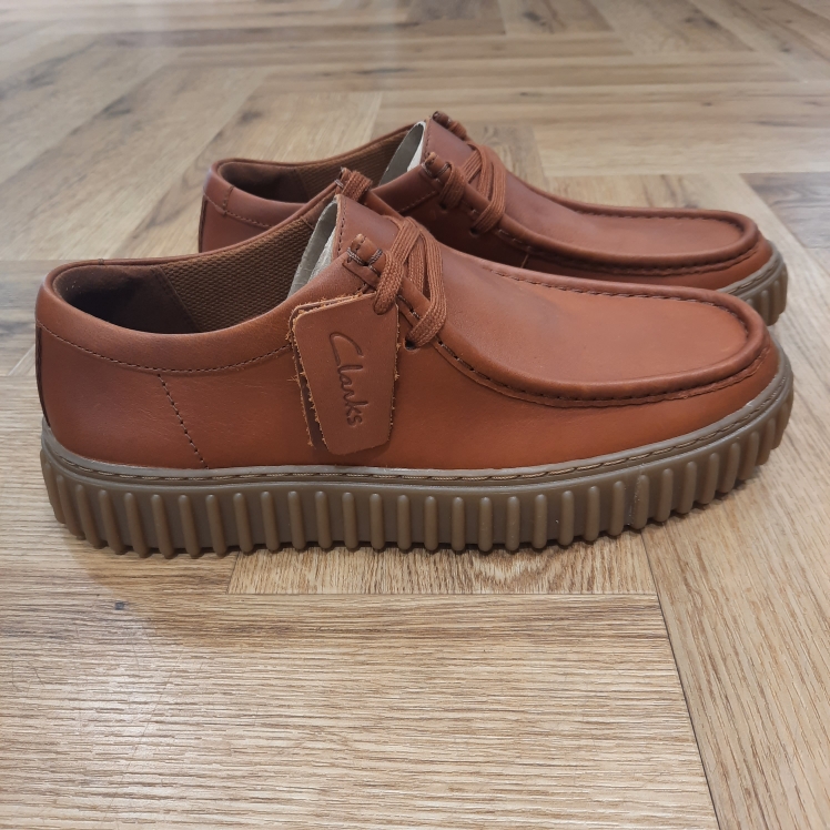 Torhill Lo Tan Complétez votre collection de chaussures en cuir avec les Clarks Torhill Lo Tan. Ces chaussures Clarks haut de gamme arborent un logo sur le côté, affirmant la signature Clarks tout en conservant une tige sobre et polyvalente. La semelle extérieure nervurée et marquante qui caractérise notre modèle Torhill Lo puise dans nos archives tout en restant aussi contemporaine aujourd’hui qu’elle l’était dans notre profil « Big Gripper » des années 90. Arborant un design épuré à lacets, dont les courbes et contours s’inspirent de notre emblématique Wallabee™, cette chaussure associe des matériaux haut de gamme à des détails soignés comme des surpiqûres délicates, pour offrir une chaussure décontractée au style heritage ultime. Nos fondateurs Notre histoire a commencé en 1825 à Street, dans le Somerset, lorsque Cyrus Clark a ouvert une tannerie de cuir, son frère James travaillant à ses côtés. Parmi les tapis en peau de mouton, James a eu un éclair d'inspiration : utiliser les chutes pour créer des pantoufles - minimiser les déchets, maximiser l'ingéniosité et définir les 200 prochaines années de la fabrication de chaussures. Chaque chaussure Clarks, depuis notre toute première paire, utilise cette combinaison distinctive d'innovation et de savoir-faire, soutenant tout ce que nous faisons. Depuis 200 ans, nous avons défini la norme - et ce n'est que le début. En 2025, nous rendons hommage au passé et au présent et célébrons fièrement cet héritage de deux siècles d'innovation et d'impact à travers un tout nouveau film, un livre, une exposition de musée et des collaborations de style.