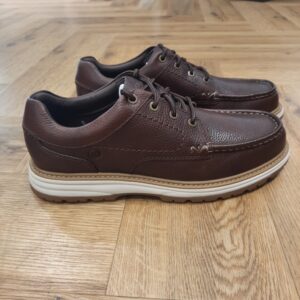 Melbury Lace Dark Brown Inspirée de notre collection Air Trek de 1993, la Melbury Lace Dark Brown apporte une touche vintage et tendance à vos tenues quotidiennes. En effet, ce modèle à lacets se distingue par son empiècement mocassin classique. De plus, son col rembourré et son assise plantaire Contour Cushion, offre un maintien confortable et un soutien durable tout au long de la journée. Nos fondateurs Notre histoire a commencé en 1825 à Street, dans le Somerset, lorsque Cyrus Clark a ouvert une tannerie de cuir, son frère James travaillant à ses côtés. Parmi les tapis en peau de mouton, James a eu un éclair d'inspiration : utiliser les chutes pour créer des pantoufles - minimiser les déchets, maximiser l'ingéniosité et définir les 200 prochaines années de la fabrication de chaussures. Chaque chaussure Clarks, depuis notre toute première paire, utilise cette combinaison distinctive d'innovation et de savoir-faire, soutenant tout ce que nous faisons. Depuis 200 ans, nous avons défini la norme - et ce n'est que le début. En 2025, nous rendons hommage au passé et au présent et célébrons fièrement cet héritage de deux siècles d'innovation et d'impact à travers un tout nouveau film, un livre, une exposition de musée et des collaborations de style.