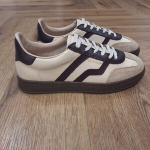 Cuzima Cream Wine Cuzima Cream Wine est un modèle d’inspiration rétro, qui se porte en toute saison. Tout d'abord, ces chaussures conçues avec une tige en cuir se distinguent par des finitions en daim lisse sur les côtés et au niveau du contrefort. Puis, la semelle extérieure en caoutchouc thermoplastique, associée à une doublure en tissu, confère un style vintage à l'ensemble. Les baskets Gant Cuzima pour femme sont la fusion parfaite entre style rétro et confort. Avec leur design intemporel et leurs matériaux de qualité supérieure, elles sont idéales pour toute occasion. Elles garantissent un look décontracté et moderne qui ne passera pas inaperçu. La marque Quand Bernard Gant, un immigrant ukrainien, arrive à New-York en 1914, il se plonge directement au cœur des métiers du prêt-à-porter. Il travaille dans un atelier de confection de chemises dans le centre de la ville. Ce n'est que quelques années plus tard, alors qu'il a déménagé à New Haven dans le Connecticut qu'il lancera l'entreprise familiale à l'aide de sa femme, également dans le métier. Rapidement, il fabrique des chemises pour les plus grandes marques du pays tel que Brooks Brothers. Si le style de Gant a beaucoup évolué au cours des années, il ne s'est jamais vraiment détaché de son image de marque Américaine traditionnelle. En effet, adepte du style Ivy avec comme produit phare la chemise à col boutonné. Après avoir été suédoise, la marque a été rachetée en 2008 par le groupe suisse Maus Frères, qui détient entre autres Lacoste et Aigle, mais elle garde encore ses valeurs originelles : celles de Bernard Gant.
