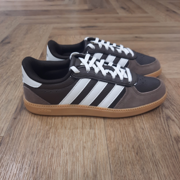 adidas breaknet sleek dark brown pour femme-Breaknet Sleek Marron-chaussures adidas pour femme-La marque adidas est l'une des marques les plus célèbres de tous les temps. Cette entreprise allemande a un nom emblématique et un logo caractéristique de trois bandes - 3 bandes, inhérentes à cette marque, connues dans le monde entier. Adidas est actuellement l'un des plus grands fabricants de vêtements de sport et de loisir, de chaussures et d' accessoires de sport au monde. Quelle est l'histoire de cette icône de la mode et du sport ? Ils ont commencé dans les toilettes et ont peu à peu conquis le monde. Toute grande histoire a un début. Celui-ci a commencé dans une petite ville de Bavière, en Allemagne. Adi Dassler a commencé dans les toilettes de sa mère, a enregistré "Gebrüder Dassler Schuhfabrik" en 1924 et il a commencé à fournir aux athlètes le meilleur équipement sportif possible. Quelques années plus tard, la coureuse Lina Radke remporte une médaille d'or à Amsterdam dans ses baskets. Ce furent les premières récompenses et étapes importantes - et seulement le début de l'histoire d'adidas.