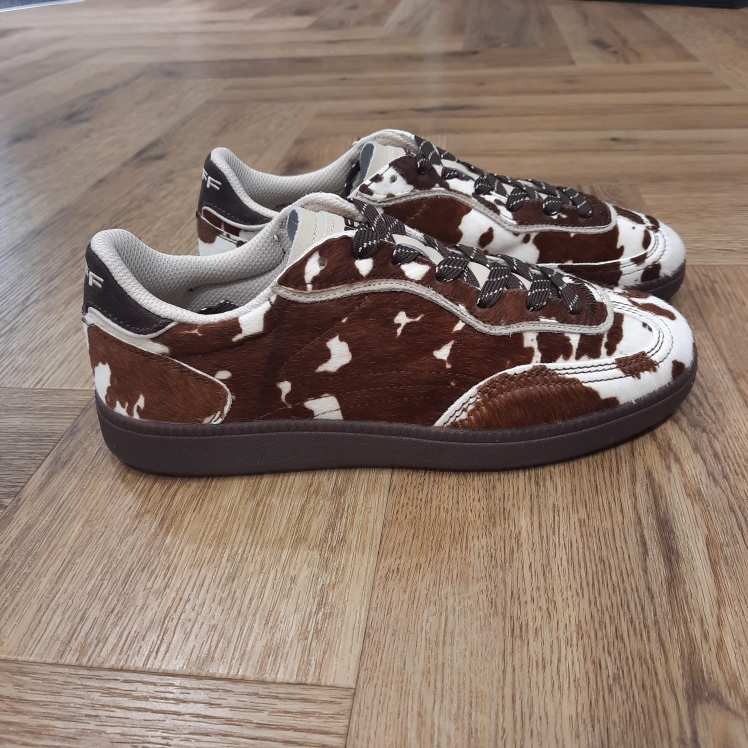 Park Cow Print Brown La sneaker Park Cow Print Brown associe une silhouette texturée et nostalgique au confort quotidien. En effet, elle est confectionnée dans une combinaison raffinée de poulain, cuir nappa et daim, fusionnant textures et tons avec un finish sophistiqué. Conçue avec un talon rembourré, une languette flexible et une semelle intérieure Memory-Foam pour une ajuste confortable et adaptable. Son empeigne en matériaux mélangés et sa semelle intérieure à mémoire de forme offrent un look raffiné. La marque Fondée en Espagne en 2017, HOFF est née de la conviction que chaque pas est une opportunité de créer, découvrir et affirmer sa personnalité. HOFF est une marque contemporaine de sneakers qui marie un design intemporel et élégant avec une polyvalence audacieuse. Reconnue pour sa créativité raffinée, son attention aux détails et sa maîtrise unique des couleurs, HOFF crée des sneakers qui s’adaptent aux transitions de la vie, transformant chaque instant du quotidien en une expression de style et de sens. Inspirée par le mouvement et la curiosité, HOFF célèbre l’individualité et l’expression de soi à travers le design. Son esthétique distinctive équilibre sophistication et modernité, brouillant les frontières entre le décontracté et le raffiné, tout en restant fidèle à ses valeurs de connexion, d’authenticité, de passion et de créativité.