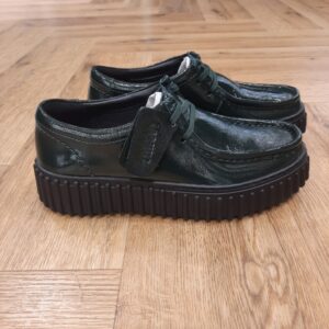 Torhill Bee Green Patent La semelle extérieure nervurée et marquante qui caractérise la boots Torhill Bee puise dans nos archives tout en conservant une allure aussi contemporaine aujourd’hui qu’elle l’était dans notre profil « Big Gripper » des années 90. Arborant un design épuré à fermeture à lacets, ses courbes et contours s’inspirent de notre emblématique Wallabee. Ce modèle associe des matériaux haut de gamme à des détails soignés, comme des surpiqûres délicates, pour offrir une chaussure décontractée au style heritage ultime. Nos fondateurs Notre histoire a commencé en 1825 à Street, dans le Somerset, lorsque Cyrus Clark a ouvert une tannerie de cuir, son frère James travaillant à ses côtés. Parmi les tapis en peau de mouton, James a eu un éclair d'inspiration : utiliser les chutes pour créer des pantoufles - minimiser les déchets, maximiser l'ingéniosité et définir les 200 prochaines années de la fabrication de chaussures. Chaque chaussure Clarks, depuis notre toute première paire, utilise cette combinaison distinctive d'innovation et de savoir-faire, soutenant tout ce que nous faisons. Depuis 200 ans, nous avons défini la norme - et ce n'est que le début. En 2025, nous rendons hommage au passé et au présent et célébrons fièrement cet héritage de deux siècles d'innovation et d'impact à travers un tout nouveau film, un livre, une exposition de musée et des collaborations de style.