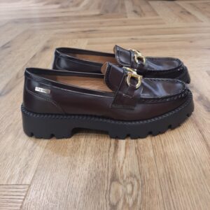 Mocassins Valmer Chocolat Ces Mocassins Valmer Chocolat en cuir sont le parfait mélange entre raffinement et praticité. Disponibles en noir et chocolat, ils s’adaptent facilement à toutes vos tenues, du bureau à vos sorties en ville. Leur semelle crantée apporte une touche contemporaine tout en assurant une excellente stabilité. Le détail doré sur le dessus et les surpiqûres autour du bout renforcent le caractère chic du modèle. Confortables et stylés, ces mocassins sont idéaux pour un usage quotidien avec une touche d’élégance. Les Tropeziennes par M. Belarbi : L’histoire d’un style intemporel, né à Saint-Tropez Mo Belarbi, né à Fez, est un créateur visionnaire et passionné par le cuir, l’artisanat et les voyages. En 1975 dans le village emblématique de Saint-Tropez dont il tombe amoureux, il ouvre son premier concept store «La Puce Tropezienne», un lieu unique, foisonnant de créativité et d’audace. Mo Belarbi, esprit libre et innovant y imagine des modèles qui deviendront iconiques, intergénérationnels et s’imposeront rapidement comme incontournables.