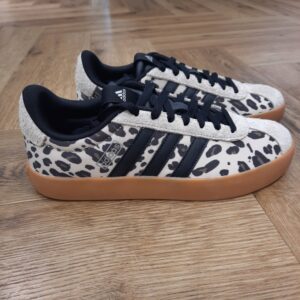VL Court Leopard Inspirée par l’emblématique design à avant-pied en T, la chaussure VL Court Leopard associe un style tennis classique avec une allure tendance et moderne. Que tu explores la ville ou que tu te retrouves entre amis, cette chaussure présente une silhouette épurée et des détails discrets pour sublimer ton look. Fabriquée avec des empiècements en matière synthétique et en suède, la tige offre durabilité et flexibilité, s'adaptant à tes mouvements tout au long de la journée. La semelle Cupsole en caoutchouc traditionnelle assure une traction fiable pour une utilisation sur la durée. Les éléments de la marque, comme les 3 bandes et le logo linéaire, ajoutent une finition signature. Adopte l'héritage adidas et mise sans hésiter sur le confort et le style. La marque C'est le 18 août 1949 qu'Adi Dassler a démarré l'aventure adidas, avec pour objectif d'améliorer les performances des athlètes. 70 ans plus tard, adidas a laissé sa marque sur le monde du sport, mais aussi celui de la mode, de la musique, de la culture, du développement durable et bien d'autres encore. Voyage avec nous à travers le temps et découvre l'histoire d'adidas avec des modèles qui ont influencé le lifestyle d'aujourd'hui. Juste après la naissance officielle des 3 bandes en 1949, les années 50 ont connu un véritable boom technologique avec des équipements innovants pour les athlètes de classe mondiale. Ainsi, c'est pendant cette décennie qu'est apparue la Samba, toujours portée de nos jours pas les joueurs de Five et de futsal, et toujours présente dans la rue. Pendant les 50's, adidas a développé une chaussure de sprint qui a battu un record du monde et la première chaussure de football conçue avec une semelle en nylon, marquant une vraie nouveauté en termes de confort et de sensations. D'autres modèles ont vu le jour durant cette période, comme la chaussure de basketball Allround, devenue une véritable icône dans les 80's. Ces années ont été révolutionnaires, créant un véritable avant et après pour les sportifs de haut niveau. Mais ce n'était que le début de l'histoire d'adidas