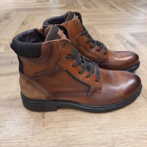 Boots Redskins Corning La CORNING revisite la boot à lacets dans un cuir tabac ciré qui se patine à l'usage. Tout d'abord, les empiècements cognac contrastés, les surpiqûres apparentes et le laçage haut structurent la tige. Puis, la semelle épaisse à débord gomme assure l'accroche et ancre le modèle dans un esprit workwear. Pour conclure, c'est la paire idéale à porter avec un jean brut, un chino épais ou un pantalon en velours côtelé, sous une parka ou un caban. L'histoire de la marque Lorsque l’on parle de la célèbre marque de cuir Redskins, on pense immédiatement au look américain, au style biker avec ce petit côté rock’n roll qui souligne la tenue masculine. Or c’est bel et bien en France qu’est née la marque, créée par Serge ABOUJEDID. C’est donc en 1984 que la marque Redskins voit le jour, inspirée de la culture américaine et de la tendance rock’n roll, empreint d’une touche contemporaine dans chaque création de la marque. Cette marque résolument française est née à Gennevilliers et oriente ses collections vers la fabrication de blousons et vestes en cuir pour homme. A partir des année 90, la marque a mis au gout du jour le modèle teddy Redskins, qui n’a de cesse d’être la pièce indémodable de votre garde-robe.
