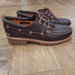 Chaussure Bateau Authentic Timberland Avec son cuir Premium Timberland® Leather résistant et sa semelle extérieure en caoutchouc emblématique, la Chaussure Bateau Authentic Timberland cousue main à 3 œillets Timberland® pour homme incarne l’authenticité à l’état pur. Tout d'abord, il est cousu à la main et doté d’un col rembourré en cuir, d’une doublure en cuir et de lacets en cuir brut. En effet, ce classique est un indispensable du vestiaire masculin, quelle que soit la saison. En achetant ce produit, vous soutenez des tanneries certifiées par le Leather Working Group. L’histoire de Timberland L’histoire des Timberland Boots remonte à la ville de Newmarket, dans le New Hampshire, aux États-Unis, où elles ont été créées en 1973. À l’origine, elles étaient destinées aux travailleurs du bâtiment et des espaces extérieurs. Les fondateurs, Nathan Swartz et sa famille, ont mis l’accent sur la qualité et la durabilité dès le départ. C’est ainsi que les premières Timberland Boots sont nées, dotées de coutures étanches, d’une semelle crantée pour une meilleure adhérence, et d’un cuir de première qualité. Cette combinaison de caractéristiques en a rapidement fait des chaussures de choix pour les travailleurs et les amateurs de plein air. Au fil des années, les Timberland Boots ont conquis un public plus large. Elles sont devenues un élément essentiel du style urbain.  Notamment dans le mouvement hip-hop des années 90, où elles ont été adoptées comme symbole de résilience et de style. Le nom « Timberland » lui-même évoque des images de forêts, de montagnes et d’aventures en plein air. Effectivement, cela en fait un choix idéal pour les esprits aventuriers.