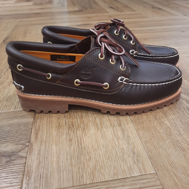 Chaussure Bateau Authentic Timberland Avec son cuir Premium Timberland® Leather résistant et sa semelle extérieure en caoutchouc emblématique, la Chaussure Bateau Authentic Timberland cousue main à 3 œillets Timberland® pour homme incarne l’authenticité à l’état pur. Tout d'abord, il est cousu à la main et doté d’un col rembourré en cuir, d’une doublure en cuir et de lacets en cuir brut. En effet, ce classique est un indispensable du vestiaire masculin, quelle que soit la saison. En achetant ce produit, vous soutenez des tanneries certifiées par le Leather Working Group. L’histoire de Timberland L’histoire des Timberland Boots remonte à la ville de Newmarket, dans le New Hampshire, aux États-Unis, où elles ont été créées en 1973. À l’origine, elles étaient destinées aux travailleurs du bâtiment et des espaces extérieurs. Les fondateurs, Nathan Swartz et sa famille, ont mis l’accent sur la qualité et la durabilité dès le départ. C’est ainsi que les premières Timberland Boots sont nées, dotées de coutures étanches, d’une semelle crantée pour une meilleure adhérence, et d’un cuir de première qualité. Cette combinaison de caractéristiques en a rapidement fait des chaussures de choix pour les travailleurs et les amateurs de plein air. Au fil des années, les Timberland Boots ont conquis un public plus large. Elles sont devenues un élément essentiel du style urbain. Notamment dans le mouvement hip-hop des années 90, où elles ont été adoptées comme symbole de résilience et de style. Le nom « Timberland » lui-même évoque des images de forêts, de montagnes et d’aventures en plein air. Effectivement, cela en fait un choix idéal pour les esprits aventuriers.