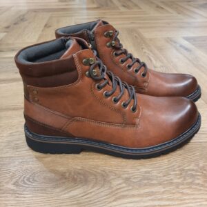 Boots Uptown Cognac Avec son coloris camel chaleureux et sa silhouette montante inspirée des boots outdoor, les Boots Uptown Cognac affiche une allure masculine, robuste et facile à porter au quotidien. Son jeu d’empiècements, son col textile contrasté et ses détails métalliques au niveau du laçage lui donnent du caractère tout en conservant un style urbain. La fermeture à lacets permet d’ajuster précisément le chaussant, tandis que la tige montante structure la silhouette. Cette bottine REDSKINS homme se distingue par ses nuances camel et marron, associées à une semelle crantée qui renforce son inspiration workwear. Le col sombre apporte un contraste discret et donne davantage de relief à l’ensemble. Pour composer un look de saison, associez cette bottine camel pour homme à un jean brut, un pull écru et une parka kaki. Elle fonctionne également très bien avec un pantalon cargo beige, un chino anthracite ou une surchemise à carreaux pour une silhouette plus casual. Une boot polyvalente et affirmée, pensée pour accompagner facilement les journées en ville et les looks automne-hiver avec une vraie touche outdoor. L'histoire de la marque Lorsque l’on parle de la célèbre marque de cuir Redskins, on pense immédiatement au look américain, au style biker avec ce petit côté rock’n roll qui souligne la tenue masculine. Or c’est bel et bien en France qu’est née la marque, créée par Serge ABOUJEDID. C’est donc en 1984 que la marque Redskins voit le jour, inspirée de la culture américaine et de la tendance rock’n roll, empreint d’une touche contemporaine dans chaque création de la marque. Cette marque résolument française est née à Gennevilliers et oriente ses collections vers la fabrication de blousons et vestes en cuir pour homme. A partir des année 90, la marque a mis au gout du jour le modèle teddy Redskins, qui n’a de cesse d’être la pièce indémodable de votre garde-robe.