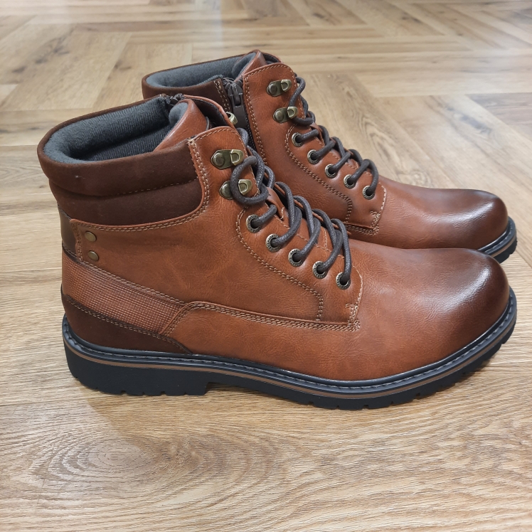 Boots Uptown Cognac Avec son coloris camel chaleureux et sa silhouette montante inspirée des boots outdoor, les Boots Uptown Cognac affiche une allure masculine, robuste et facile à porter au quotidien. Son jeu d’empiècements, son col textile contrasté et ses détails métalliques au niveau du laçage lui donnent du caractère tout en conservant un style urbain. La fermeture à lacets permet d’ajuster précisément le chaussant, tandis que la tige montante structure la silhouette. Cette bottine REDSKINS homme se distingue par ses nuances camel et marron, associées à une semelle crantée qui renforce son inspiration workwear. Le col sombre apporte un contraste discret et donne davantage de relief à l’ensemble. Pour composer un look de saison, associez cette bottine camel pour homme à un jean brut, un pull écru et une parka kaki. Elle fonctionne également très bien avec un pantalon cargo beige, un chino anthracite ou une surchemise à carreaux pour une silhouette plus casual. Une boot polyvalente et affirmée, pensée pour accompagner facilement les journées en ville et les looks automne-hiver avec une vraie touche outdoor. L'histoire de la marque Lorsque l’on parle de la célèbre marque de cuir Redskins, on pense immédiatement au look américain, au style biker avec ce petit côté rock’n roll qui souligne la tenue masculine. Or c’est bel et bien en France qu’est née la marque, créée par Serge ABOUJEDID. C’est donc en 1984 que la marque Redskins voit le jour, inspirée de la culture américaine et de la tendance rock’n roll, empreint d’une touche contemporaine dans chaque création de la marque. Cette marque résolument française est née à Gennevilliers et oriente ses collections vers la fabrication de blousons et vestes en cuir pour homme. A partir des année 90, la marque a mis au gout du jour le modèle teddy Redskins, qui n’a de cesse d’être la pièce indémodable de votre garde-robe.
