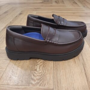 Highwood Loafer Chocolat Les Birkenstock Highwood Loafer Chocolat allient le style intemporel des mocassins et le confort emblématique des Birkenstock. En effet, le modèle réinterprète la forme Penny classique et offre la combinaison parfaite entre élégance et fonctionnalité, convenant parfaitement à un port quotidien. D'abord, le lit de pied Deep Blue, confortable et léger, rend ces chaussures agréables à porter en toutes circonstances, surtout durant de longues journées bien chargées. Puis, l’élément distinctif de cette variante est sa semelle en caoutchouc de grande qualité, dont le profil inspiré du monde professionnel offre une excellente adhérence. De plus, les éléments profilés, placés de manière à soutenir les propriétés biomécaniques du pied, favorisent son déroulement naturel et assurent un maximum de confort lors de la marche. Enfin, la tige se compose d’un cuir aniline haut de gamme et particulièrement brillant. L’histoire de Birkenstock Tout commence en 1774, lorsque Johann Adam Birkenstock, un cordonnier allemand passionné, fonde ce qui allait devenir l'une des marques de chaussures les plus emblématiques au monde. À l'époque, Johann menait une petite entreprise modeste qui lui permettait de vivre confortablement. Mais comment cette production familiale a-t-elle pu se transformer en un empire mondial de la chaussure ? Le tournant se produit en 1896 avec Konrad Birkenstock, un descendant de la famille. Konrad, visionnaire, décide de donner un coup de jeune à l'entreprise familiale. C'est lui qui a développé la première semelle intérieure orthopédique, une innovation qui a littéralement mis le sabot Birkenstock sur la carte mondiale. Cependant, il aura fallu plusieurs générations et une évolution constante pour que Birkenstock devienne la marque internationale que l'on connaît aujourd'hui. Le grand bond en avant s’est produit au XXe siècle, notamment aux États-Unis dans les années 1960, où les sandales Birkenstock sont devenues un symbole de la contre-culture et du confort.