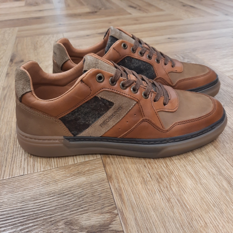 Redskins Lerma Cognac La Redskins Lerma Cognac associe un cuir lisse cognac ciré à des empiècements en daim beige, pour une basse à la fois nette et chaleureuse. De plus, les perforations discrètes, le col matelassé et le marquage Redskins ton sur ton composent une finition soignée. Puis, la semelle en gomme, à petit débord, apporte le confort sans alourdir. À porter avec un chino, un jean délavé ou un pantalon en lin. L'histoire de la marque Lorsque l’on parle de la célèbre marque de cuir Redskins, on pense immédiatement au look américain, au style biker avec ce petit côté rock’n roll qui souligne la tenue masculine. Or c’est bel et bien en France qu’est née la marque, créée par Serge ABOUJEDID. C’est donc en 1984 que la marque Redskins voit le jour, inspirée de la culture américaine et de la tendance rock’n roll, empreint d’une touche contemporaine dans chaque création de la marque. Cette marque résolument française est née à Gennevilliers et oriente ses collections vers la fabrication de blousons et vestes en cuir pour homme. A partir des année 90, la marque a mis au gout du jour le modèle teddy Redskins, qui n’a de cesse d’être la pièce indémodable de votre garde-robe.
